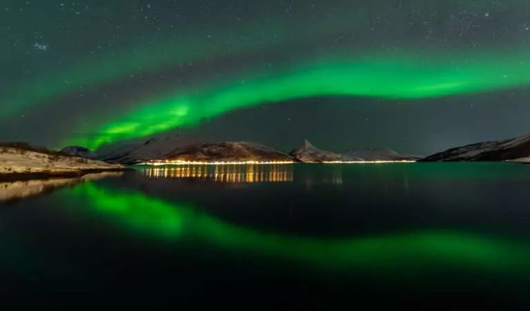 Spiegelung von Nordlichter über einem Fjord in Senja