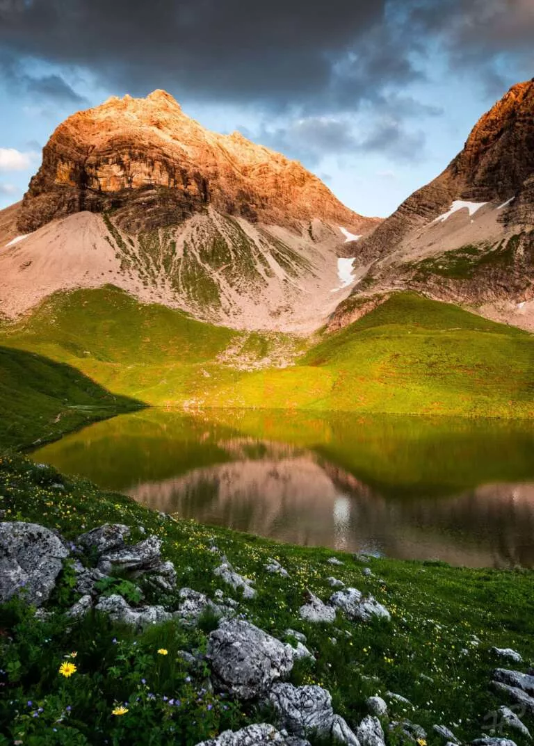 Alpenglühen an einem Bergsee im Allgäu
