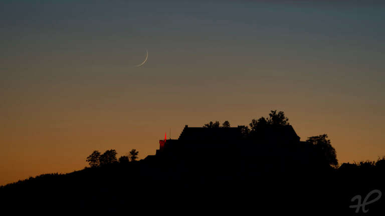 Schloß Staufenberg mit roter Beleuchtung und Mondsichel