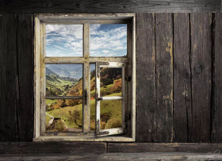 Blick durch ein Holzfenster in die Landschaft