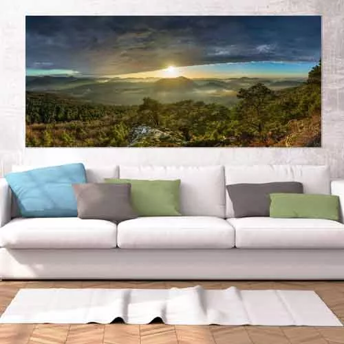 Ein Fine Art Panorama Wandbild von Heimatfotos, gedruckt im UV-Direktdruck hinter mattes Acrylglas, in einem Wohnzimmer über dem Sofa. Das Wandbild zeigt ein Panorama aus dem Pfälzer Wald bei Sonnenuntergang mit Wolken. Das Foto ist von unserem Heimatlicht und Fotograf Christian Fernandez Gamio