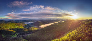 Die Pfalz von oben „Pfälzerwald“, Panorama des Dahner Felsenland mit leuchtendem Wald zum Sonnenaufgang im April