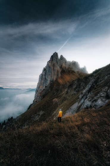 Eine Wanderin in gelber Daunenjacke an der Saxer Lücke in den Appenzeller Alpen in der Schweiz im Sommer