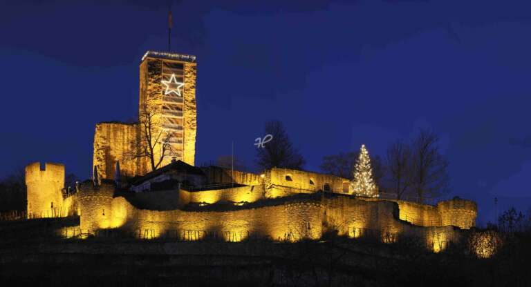 Die weihnachtlich geschmückte Wachtenburg bei Nacht