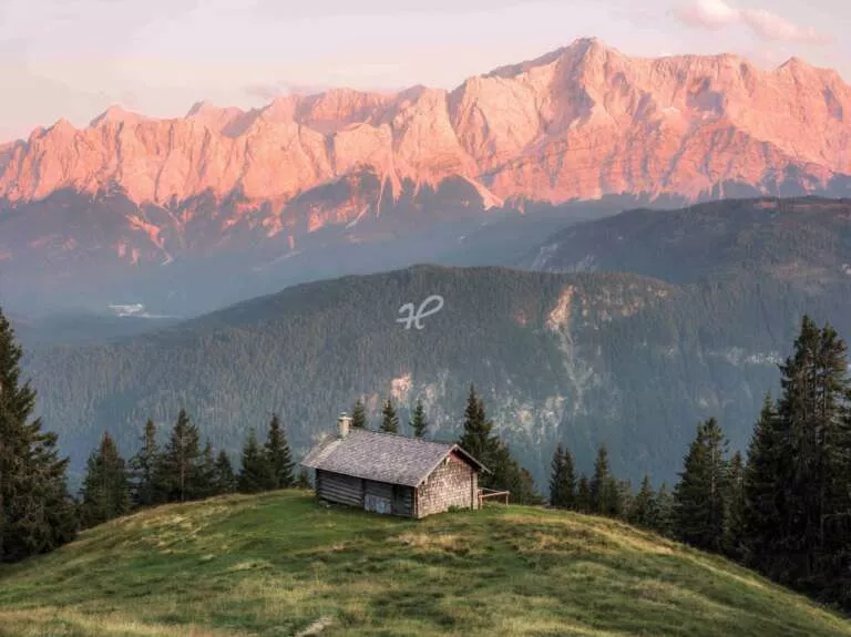 Eine einsame Alm mit roten Bergen im Karwendel in den Bayerischen Alpen
