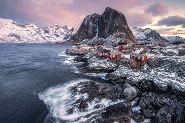 Rote Häuser am Meer in Norwegen mit blick auf die Berge
