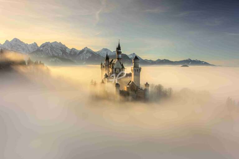 Luftaufnahme vom Schloss Neuschwanstein über dem Nebel im Winter