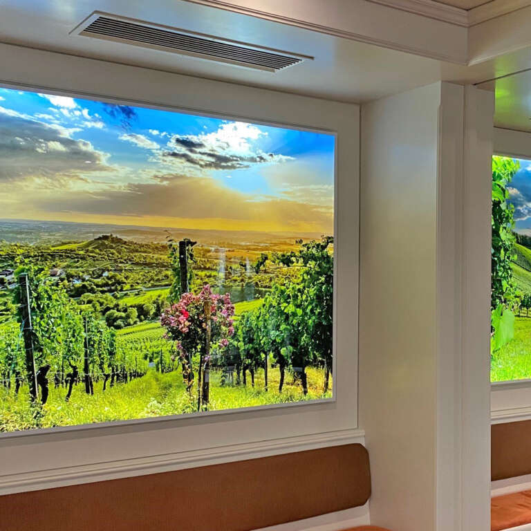 Zwei sehr große Leuchtkästen mit regionalen Motiven aus dem Remstal hängen im Weinstadt Hotel im Seminarraum