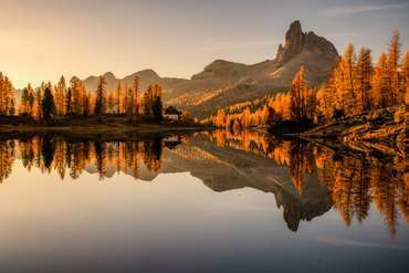 Federasee in Südtirol in Italien im Herbst mit spiegelglattem Wasser und Sonnelicht