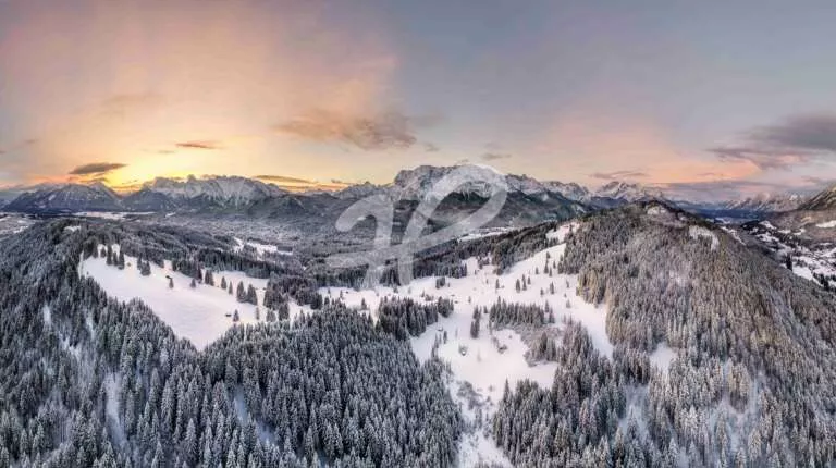 Panorama einer Winterlandschaft als Luftaufnahme vom Sonnenaufgang mit kleinen hütten und bäumen
