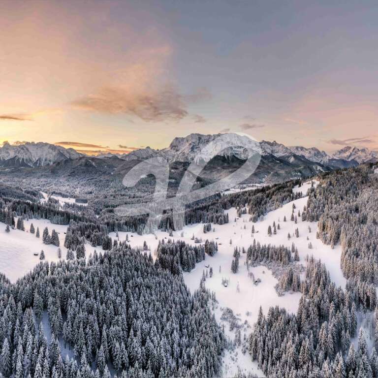 Panorama einer Winterlandschaft als Luftaufnahme vom Sonnenaufgang mit kleinen hütten und bäumen