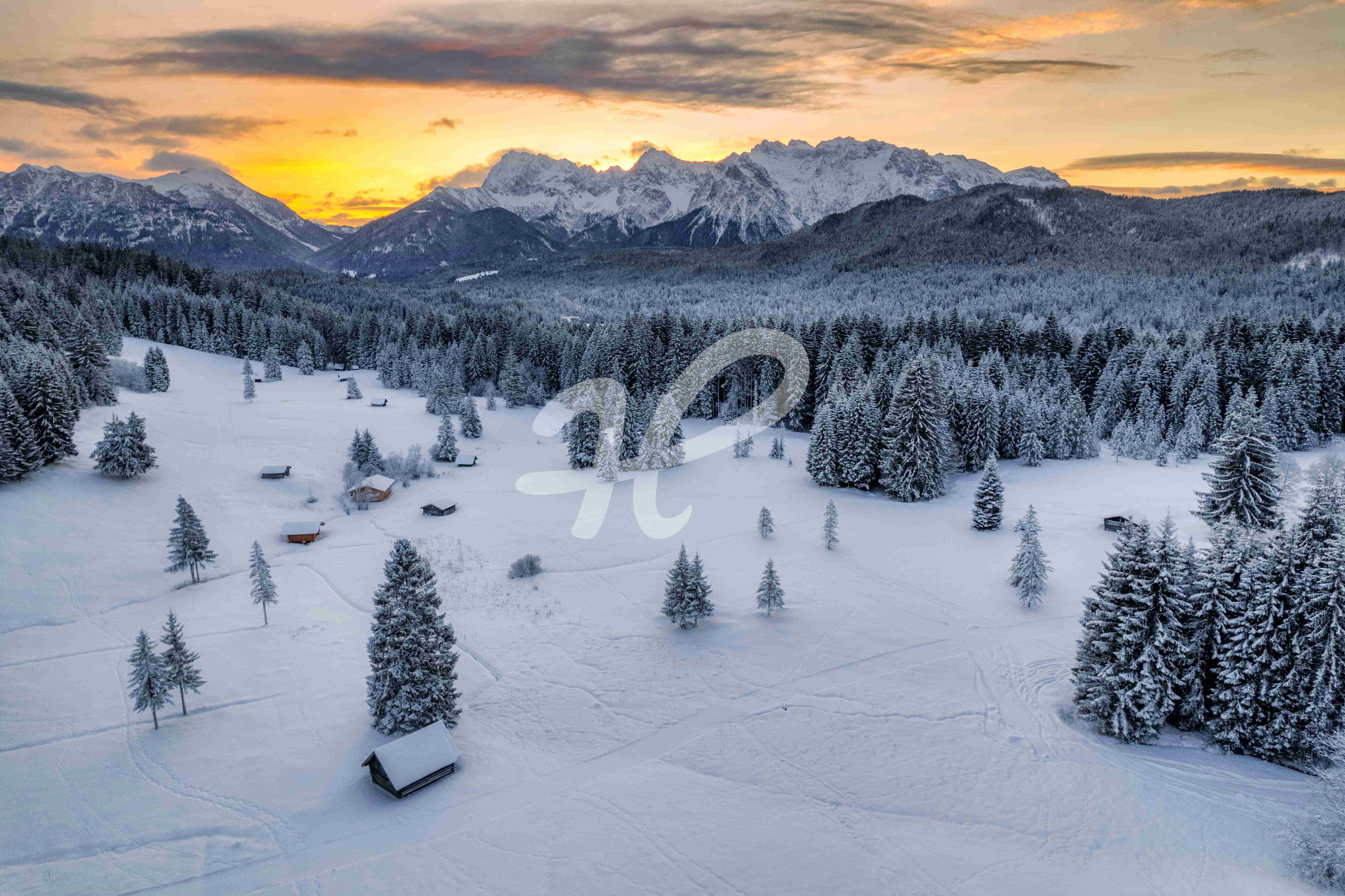 Kleine hütten in einer winterlichen Landschaft umgeben von Bergen in Bayern
