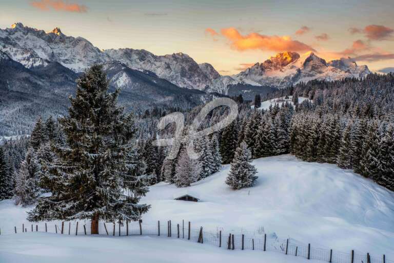 Winterlandschaft mit Neuschnee und einer Hütte in den Bergen in Bayern