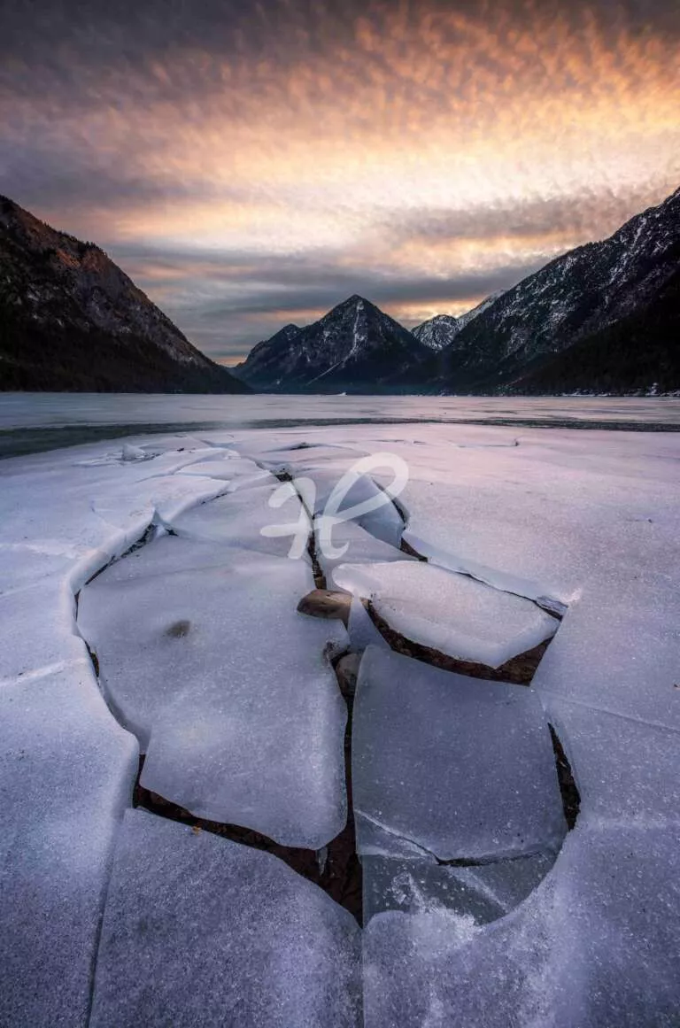 Gebrochenes Eis an einem See zum Sonnenaufgang