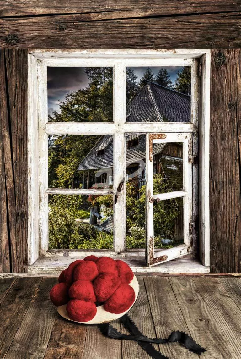 Schwarzwälder Bollenhut vor einem rustikalem Holzfenster