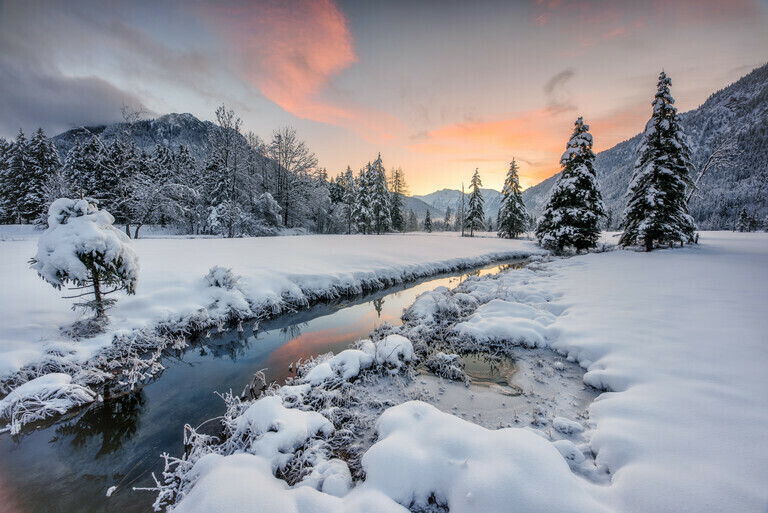 Ein Bach im Winter mit viel Schnee in einer verschneiten Landschaft