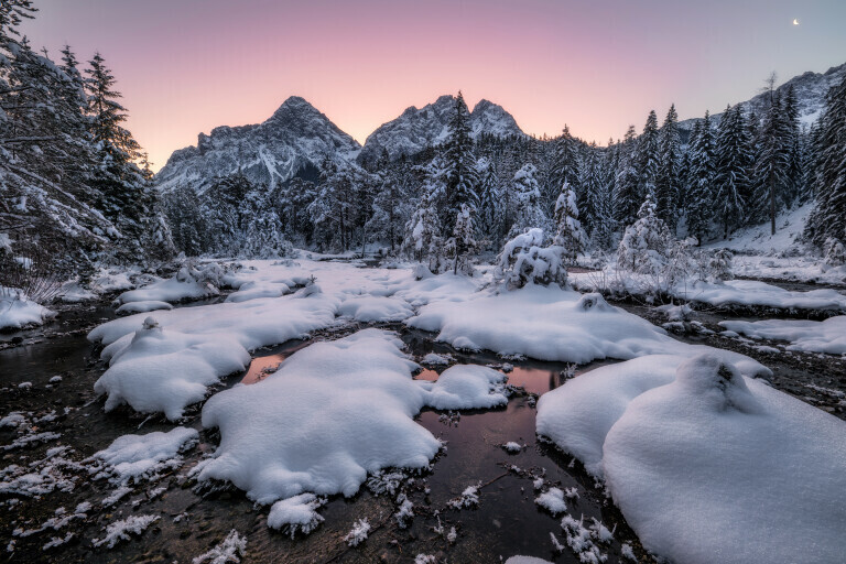 Winterlandschaft mit Fluss und Bergen zum Sonnenaufgang