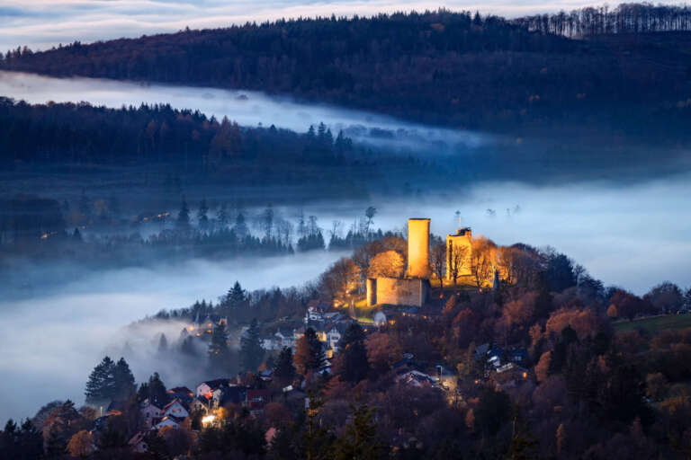 Blaue Stunde über dem Taunus: Nebelschichten und die Ruinen von Oberreifenberg vom Großen Feldberg aus gesehen