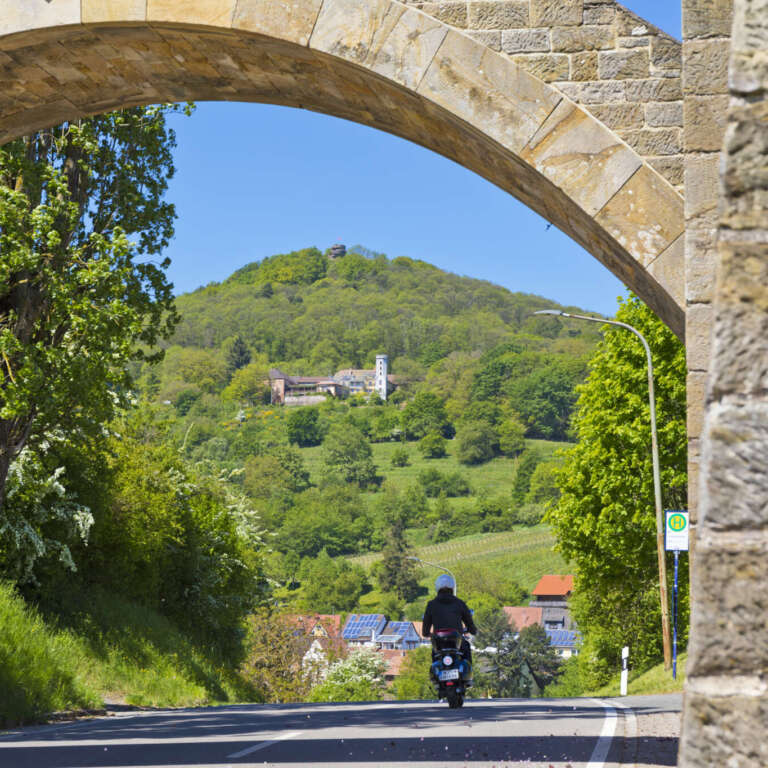 Sandsteinbogen am Leinsweilerhof mit Blick auf den Slevogthof und die Burgruine Neukastel