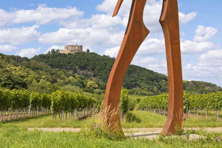 Blick vorbei an der Skulptur „Wächter“ auf dem Kunstpfad Maikammer zum Hambacher Schloss