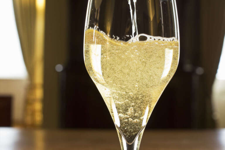 Sekt wird in ein Sektglas eingeschenkt
